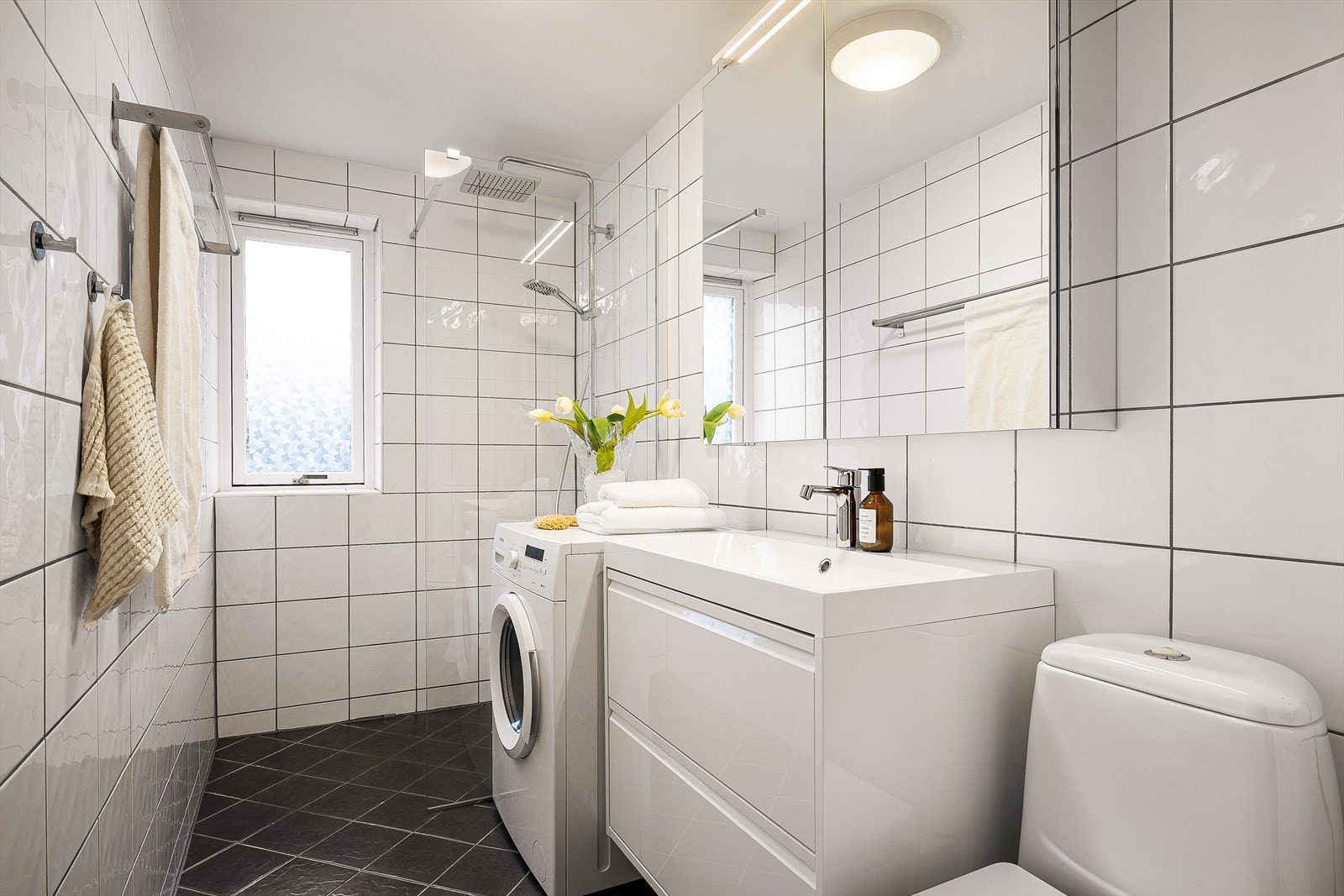 Tidløst bad på 4,2m² med varmekabler i gulv. Praktisk med opplegg for vaskemaskin i leiligheten. Galleribilde