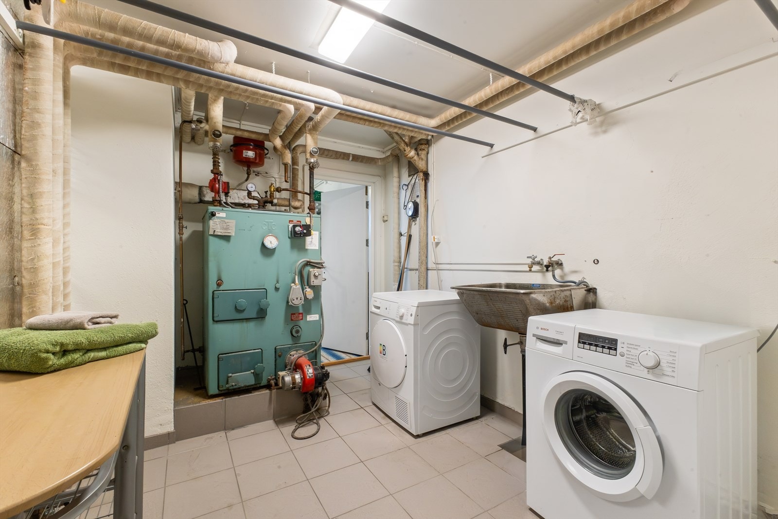 Teknisk rom. Fyrkjelen har fått installert el-kolbe og benytter hovedsakelig denne for oppvarming av radiatorer rundt om
i boligen. For øvrig brukes dette som vaskerom i tillegg. Det er også to varmepumper i boligen. Galleribilde