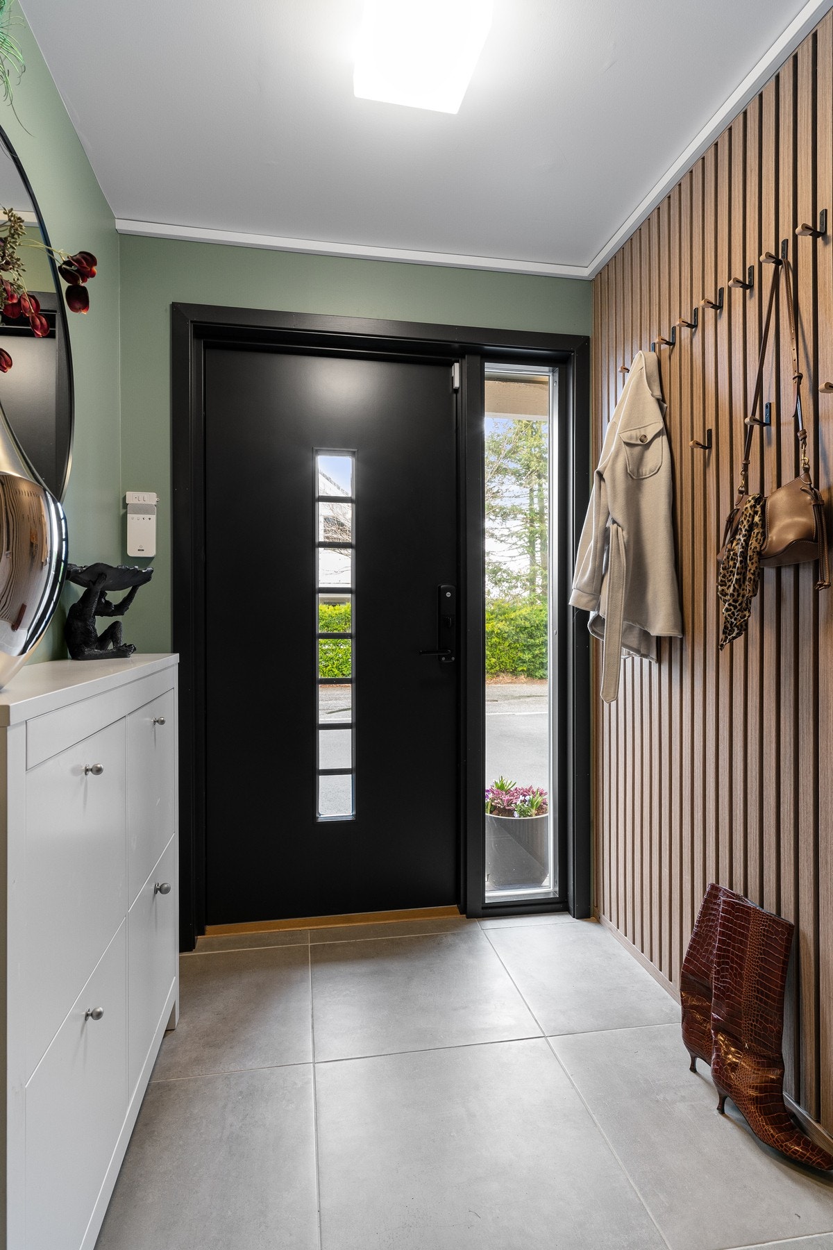 Entréen gir et godt førsteinntrykk med flislagt gulv og en stilren spilevegg. Her er det plass til å henge fra seg yttertøy og sette fra seg sko. Galleribilde