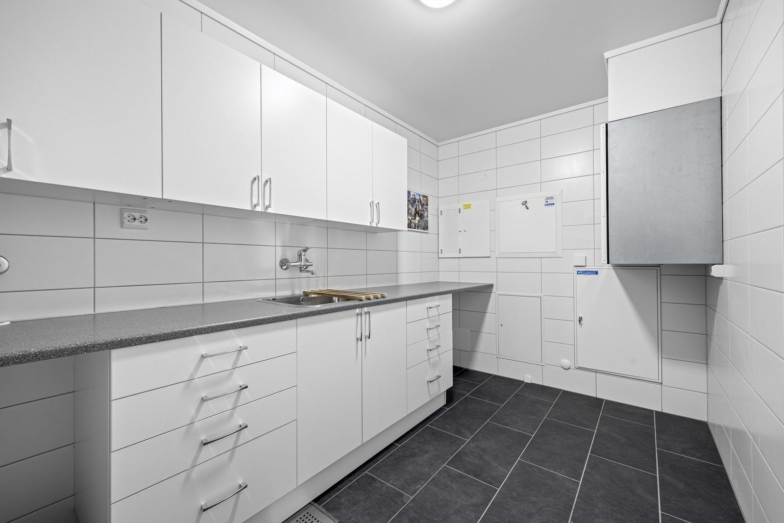 Vaskerom/teknisk rom med skap og plass til både vaskemaskin og tørketrommel. Galleribilde