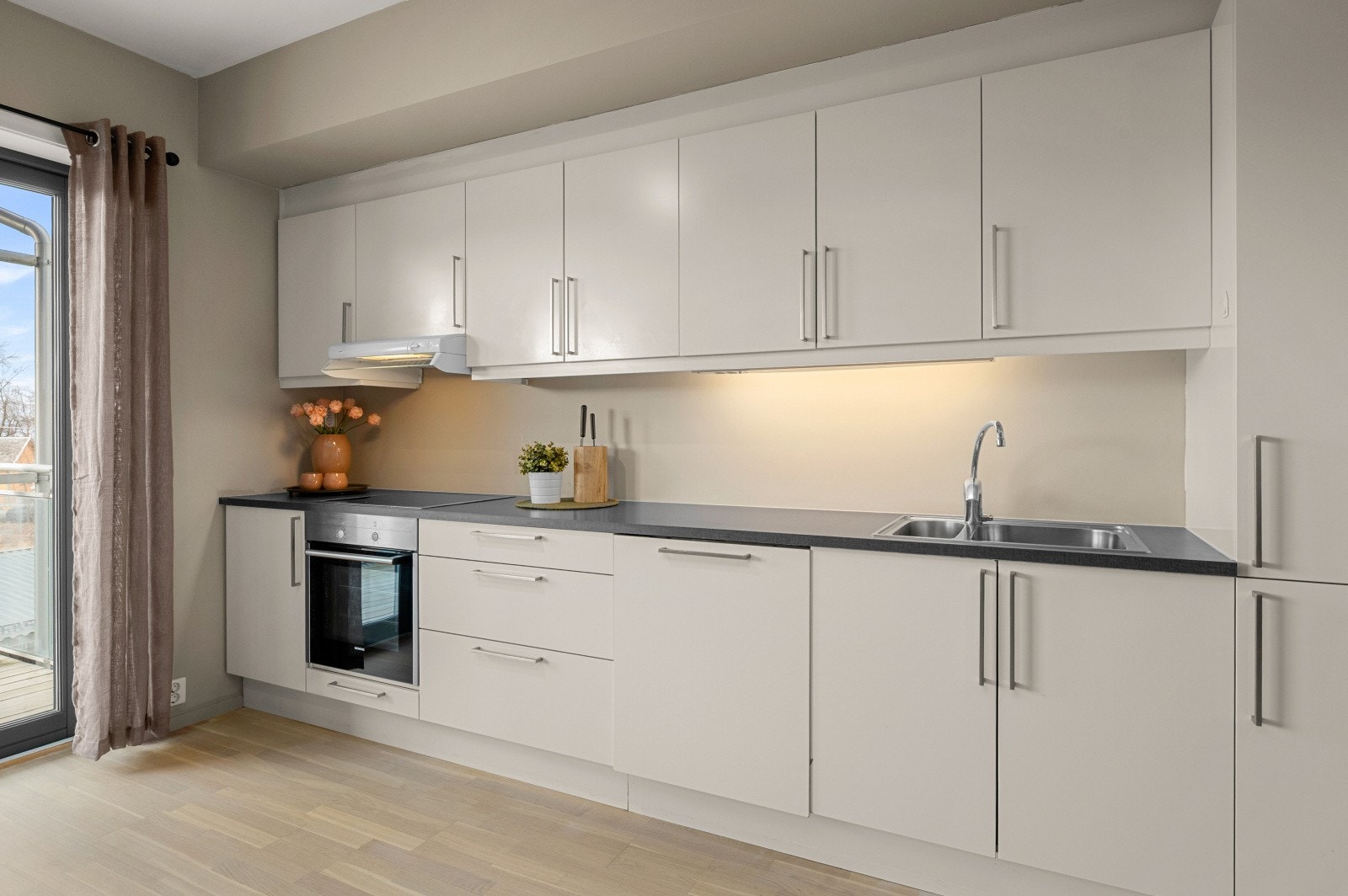 Lekkert kjøkken med mye lagringsplass, integrerte hvitevarer med komfyr, kombiskap med fryser, oppvaskmaksin og steketopp. Galleribilde