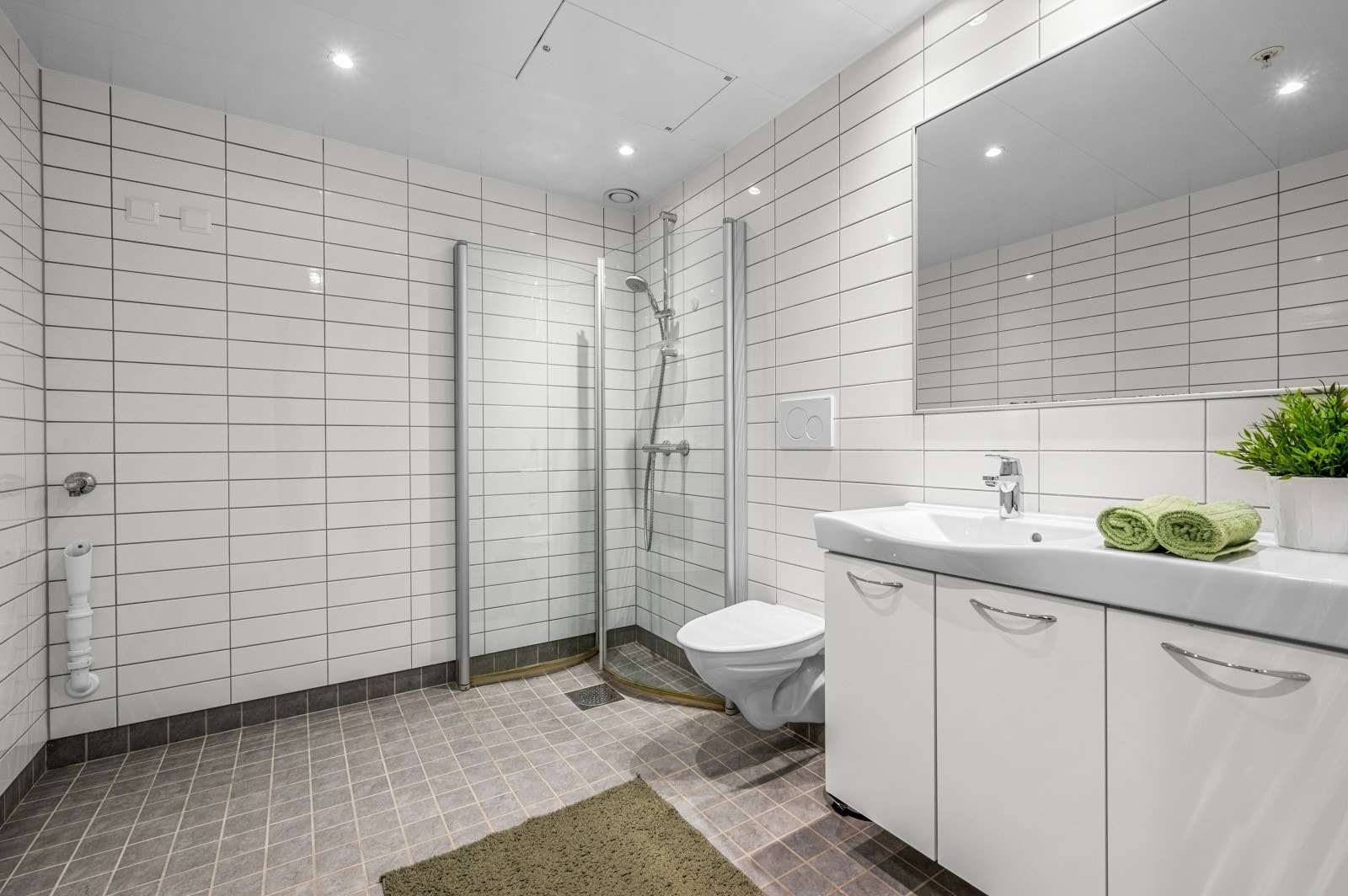 Leiligheten har lekkert og flislagt bad på 5,5 kvm. med gulvvarme, god plass til vaskemaskin og tørketrommel og innfellbare dusjdører. Godt med lagringsplass i baderomsinnredning. Galleribilde