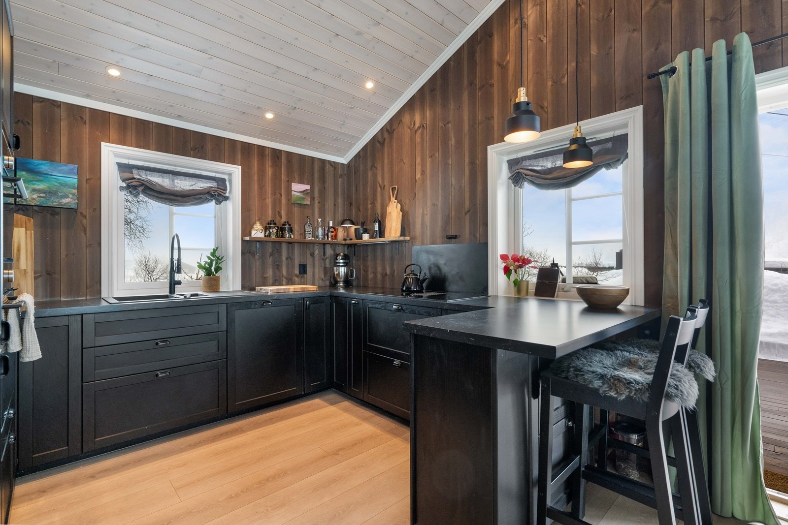 Hyttens kjøkken er et samlingspunkt med sin stilrene hytteinnredning i sort utførelse. Galleribilde