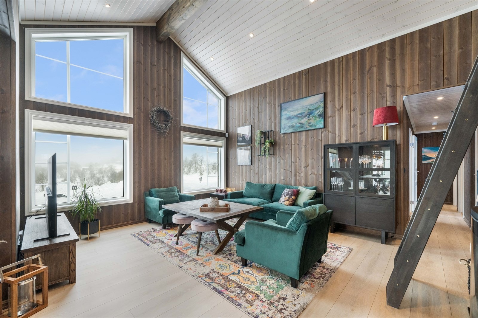 Hyttens hjerte er den vakre stuen med mønt himling og høye vindusflater som slipper inn rikelig med lys og gir flott utsikt til naturen utenfor. Galleribilde