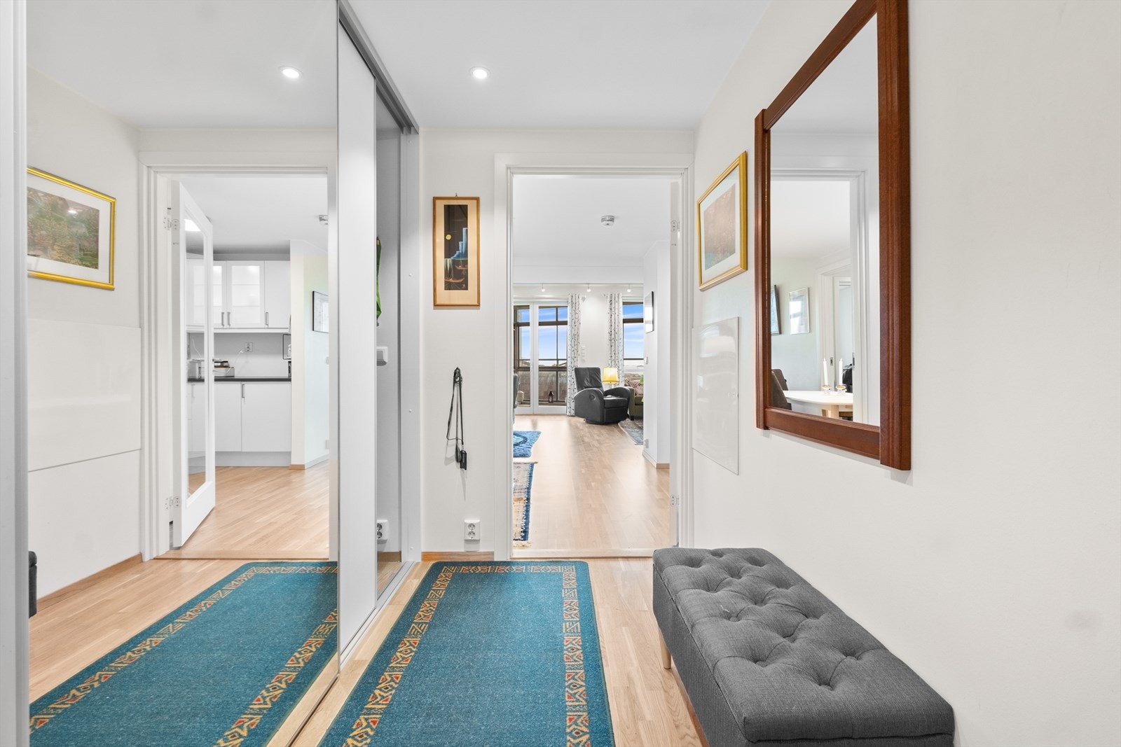 Entréen har god plass til oppbevaring i en praktisk skyvedørsgarderobe.Fra entréen åpner leiligheten seg opp mot stuen og kjøkkenet, noe som gir en umiddelbar følelse av romslighet. Galleribilde