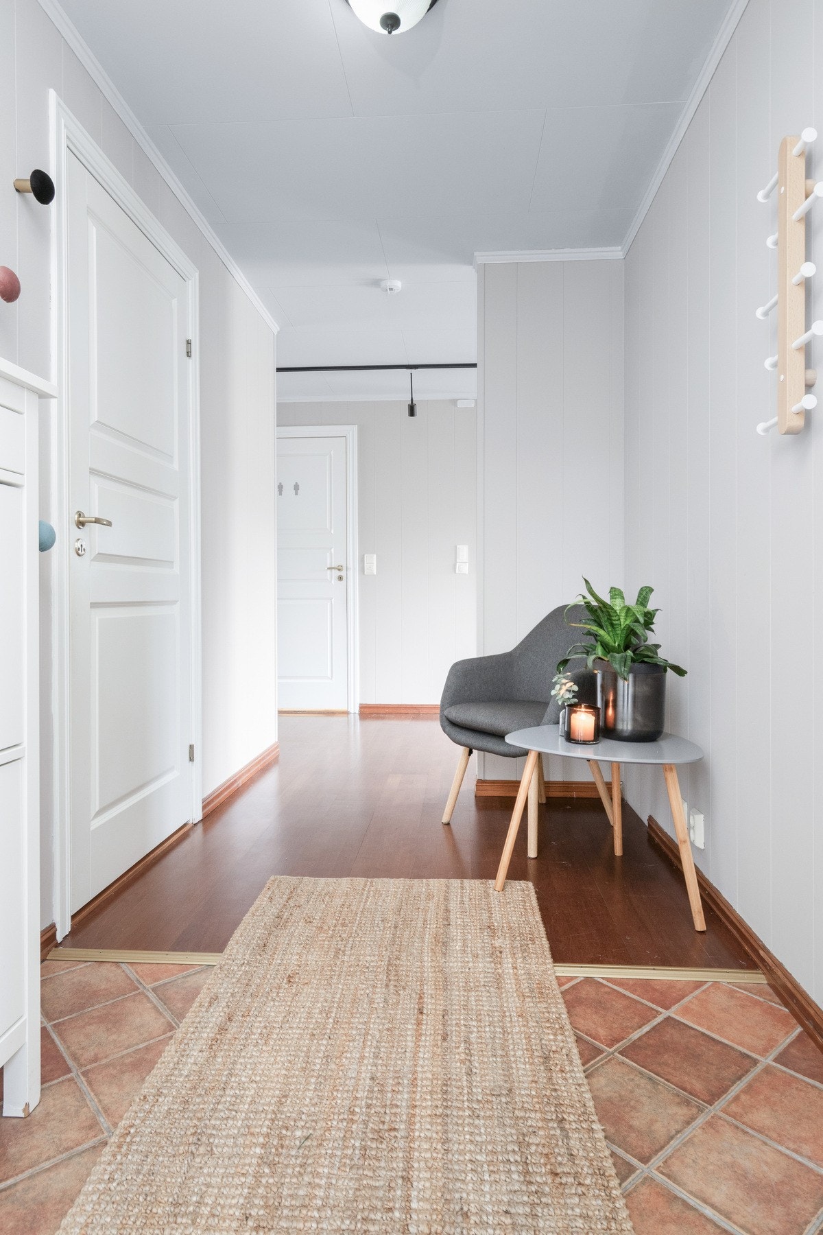 Romslig gang med fliser og parkett på gulvet. Galleribilde