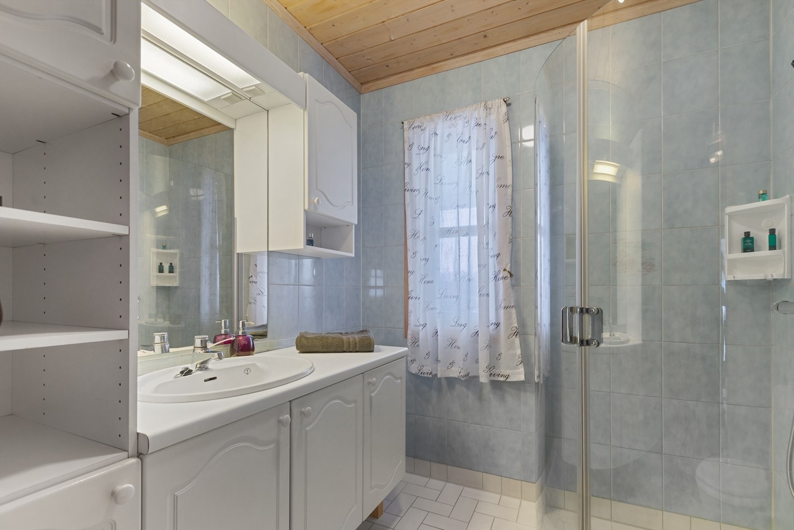 Innredningen inkluderer servantskap med profilerte fronter og belyst speil. Rommet har mekanisk avtrekk. Galleribilde