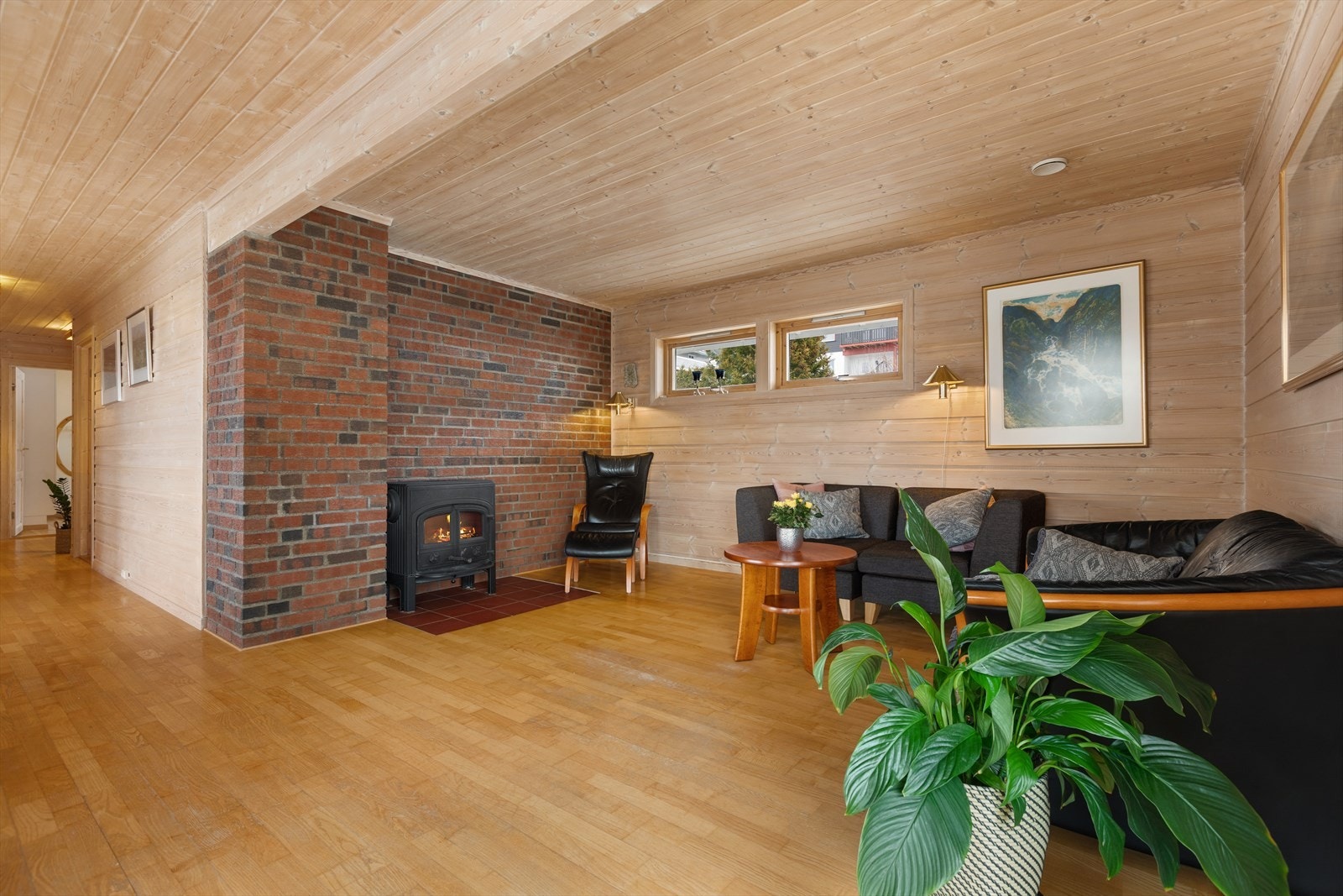 En teglsteinsvegg rammer inn ildstedet og gir rommet karakter. Galleribilde