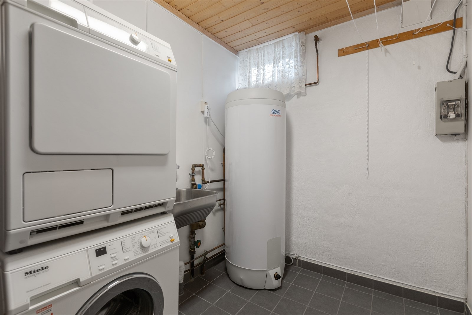 Praktisk vaskerom oppgradert i 2021 med nye fliser, membran og varmekabler. Her står en OSO-bereder fra 2021. Galleribilde