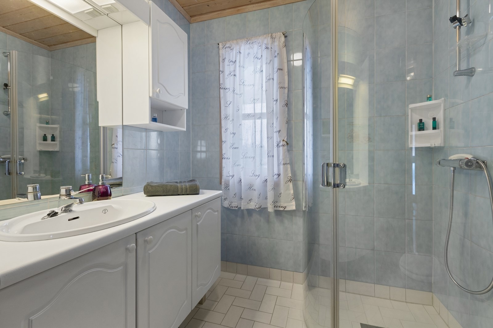 Badet i første etasje har flislagte overflater, varmekabler i gulvet og dusjhjørne med innfellbare dører. Galleribilde