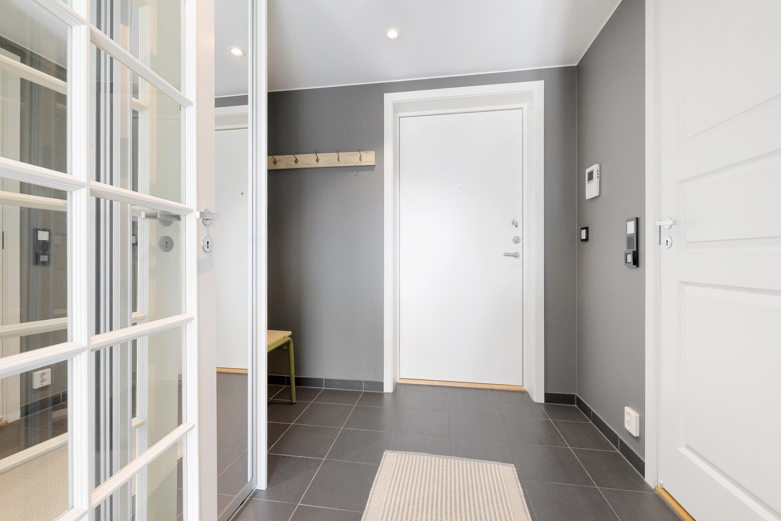 Gangen fremstår som funksjonell og luftig, med god plass til oppbevaring. Her er det satt opp en skyvedørsgarderobe med speilfronter, som både gir rikelig lagringsplass. Galleribilde
