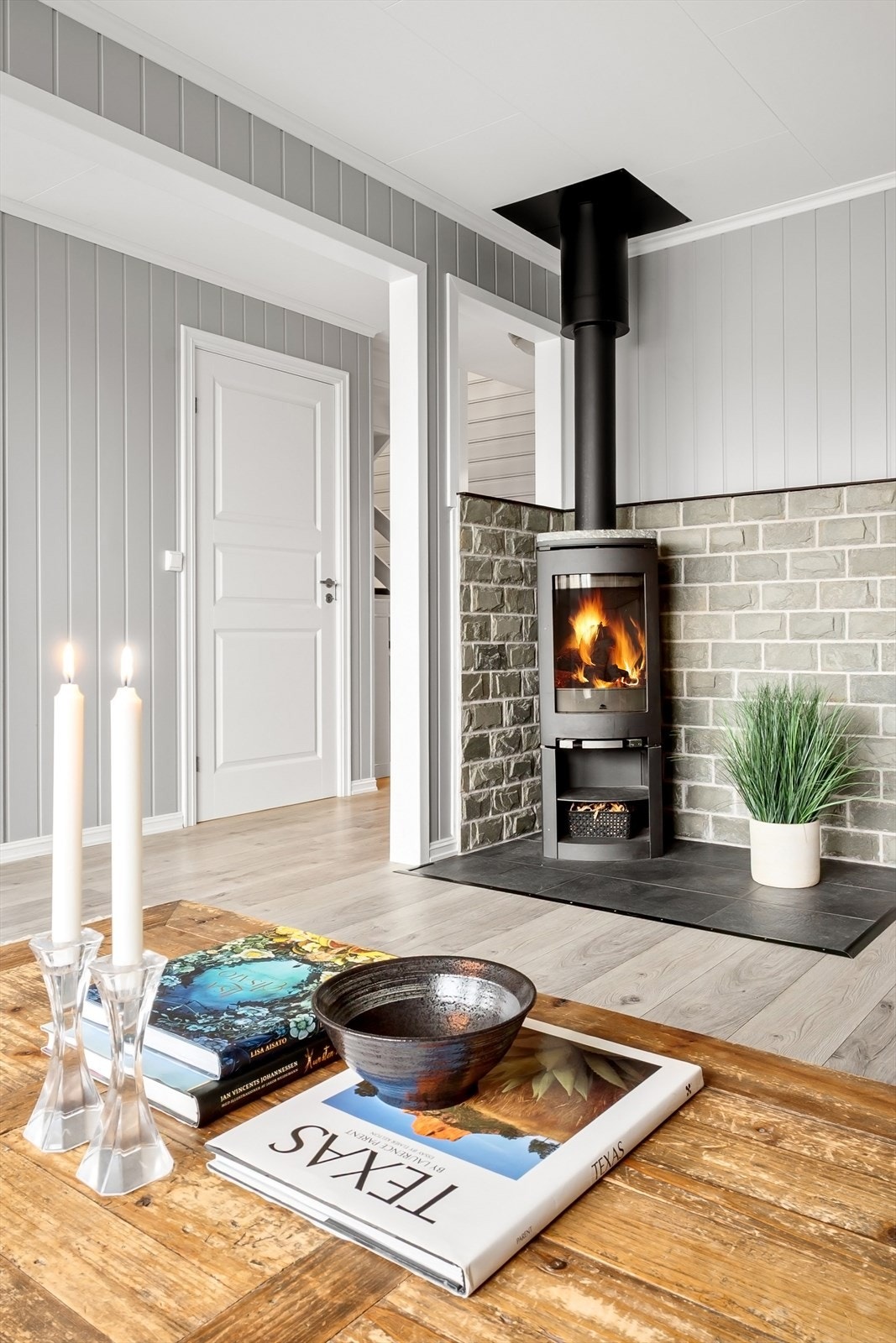 Ved sofakroken står en peisovn med glassfelt som gir både god varme og hygge på kjølige dager. Galleribilde