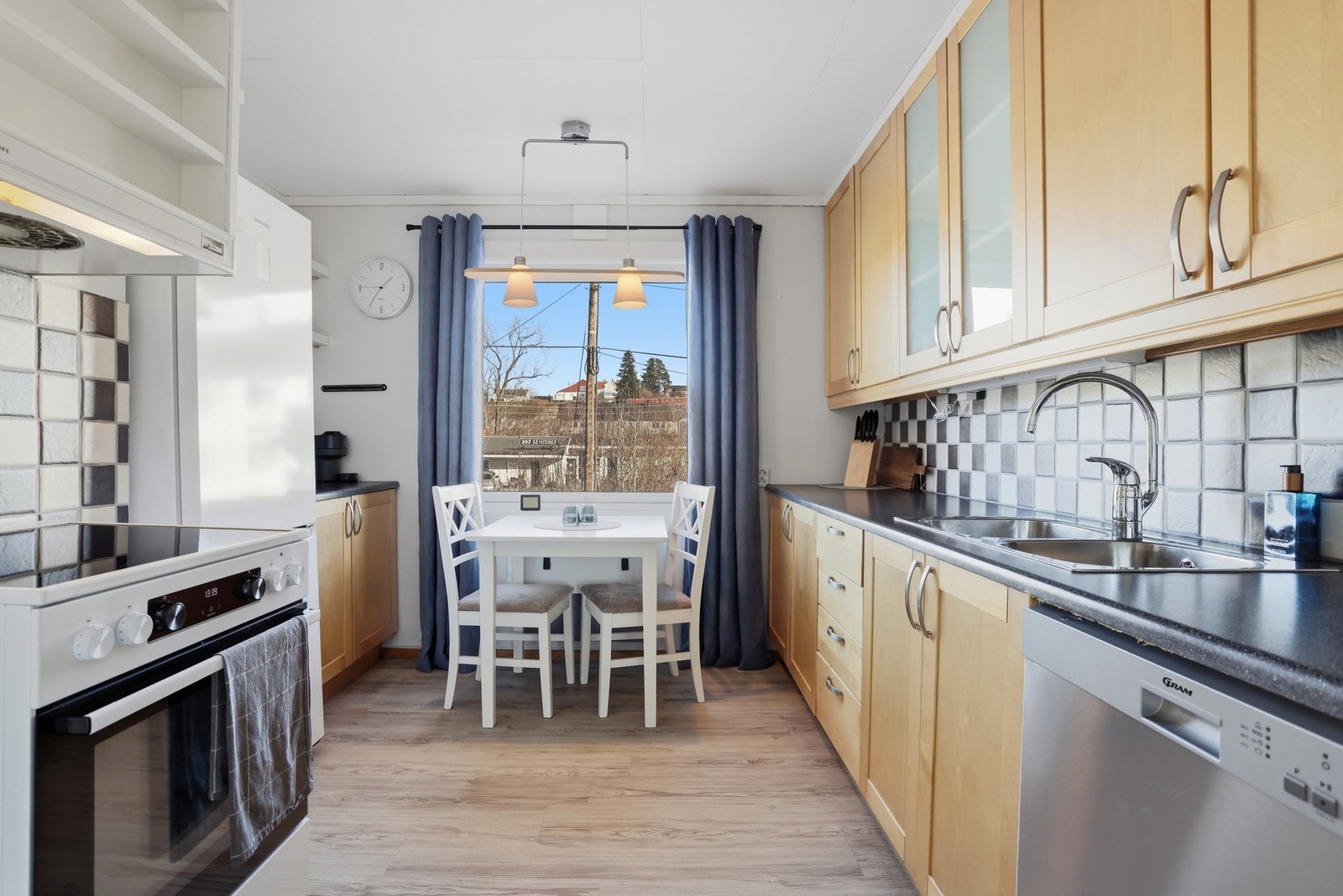 Kjøkkeninnredning med laminat benkeplate. Det er opplegg for vaskemaskin og ellers frittstående hvitevarer som komfyr og kjøl/fryseskap. Galleribilde