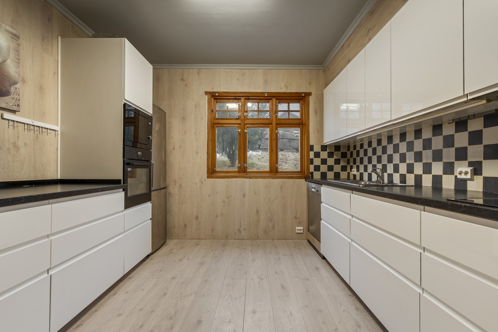 Kjøkkenet består av en moderne innredning med slette fronter i høyglans og benkeplate av laminat med nedfelt vask. Galleribilde