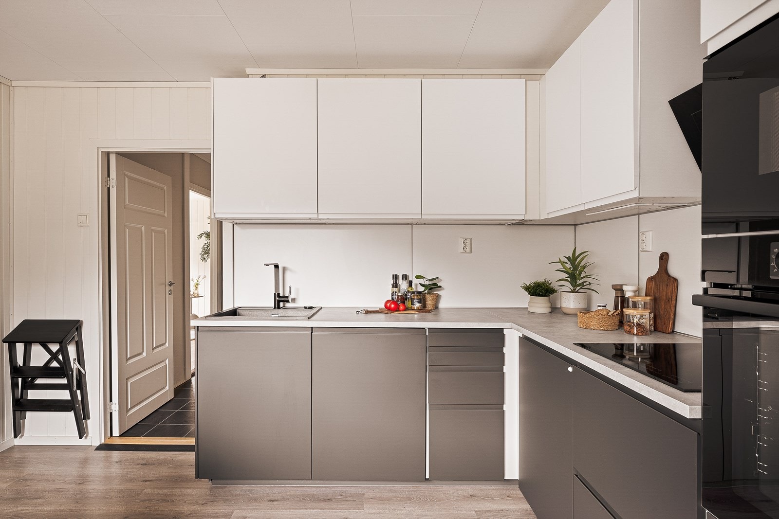 Stilig kjøkken med to ulike farger på over- og underskap. Her er det også opplegg for vaskemaskin, stekeovn og micobølgerovn. Galleribilde