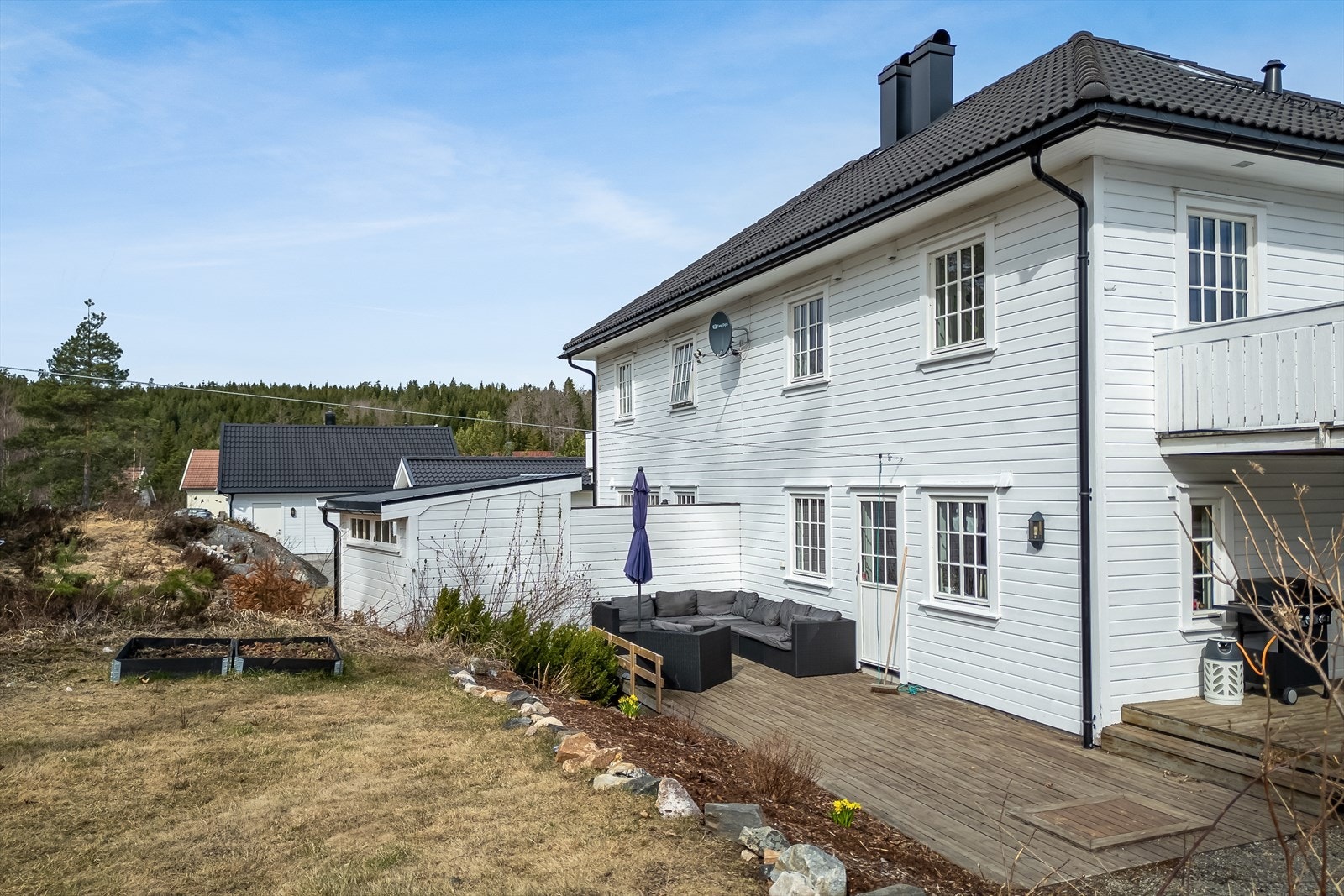 Uteområde fra baksiden av boligen - det er bed rundt platting Galleribilde