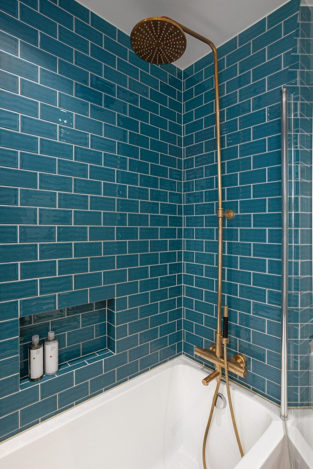 Badet har badekar med regnfallsdusj. Galleribilde
