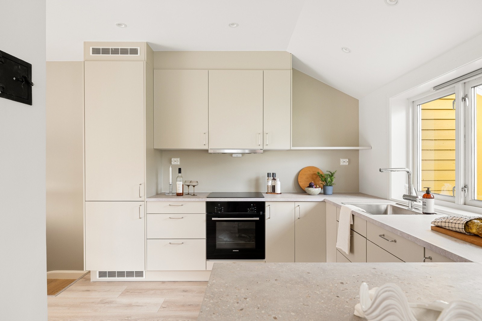 En praktisk halvøy gir ekstra arbeids- og serveringsplass og fungerer som et naturlig samlingspunkt. Galleribilde