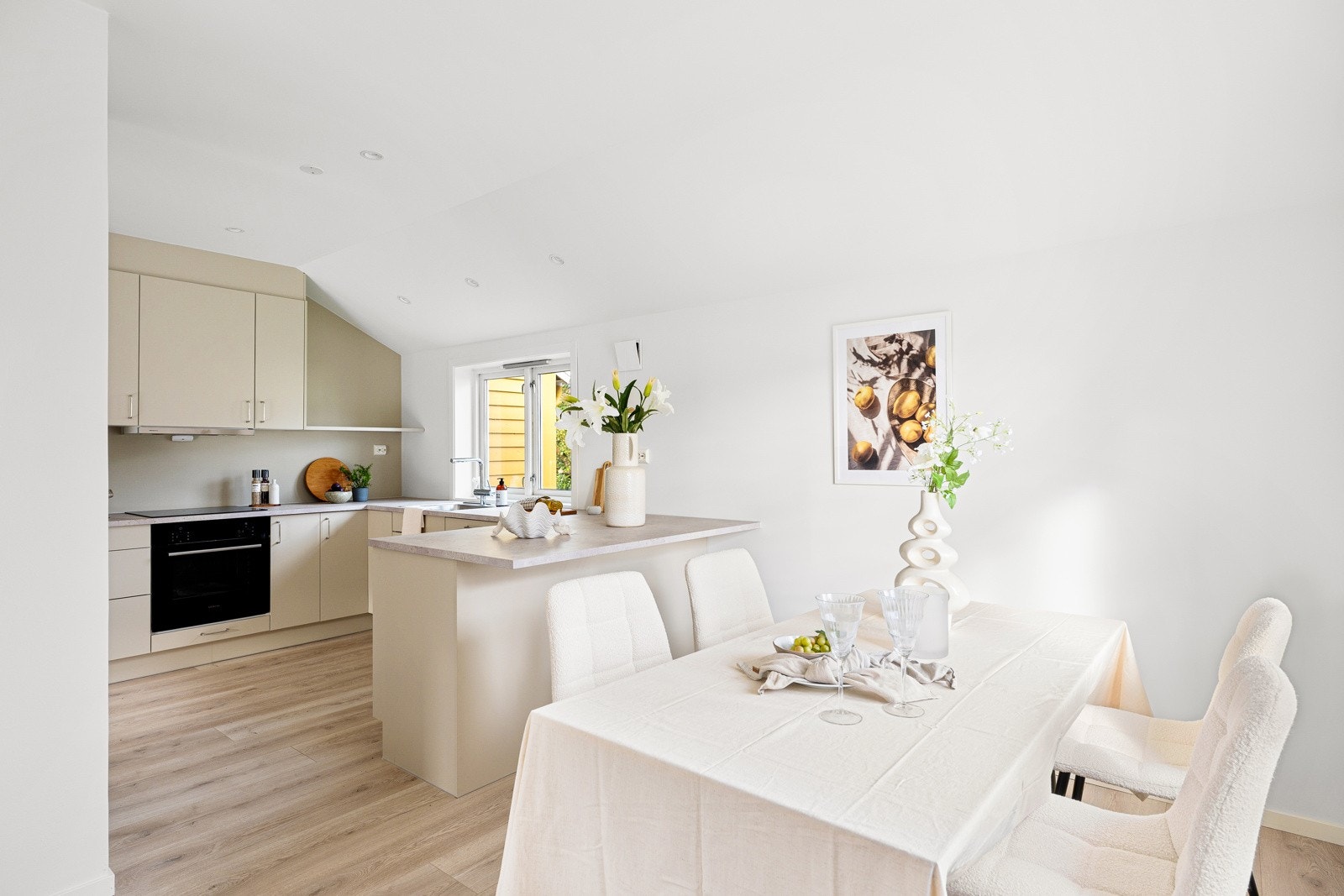 Den åpne planløsningen mellom stue og kjøkken gir rikelig plass til både spisebord og sofagruppe. Galleribilde