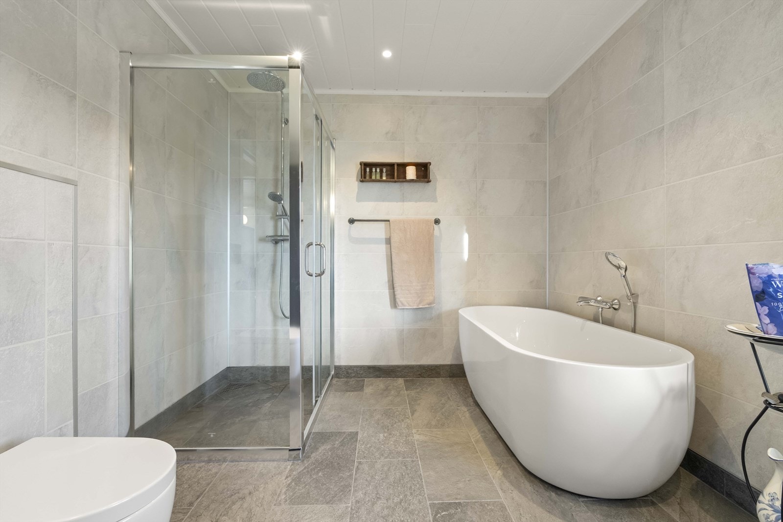 Badet vart oppgradert i 2022 med skiferfliser på golv, varmekablar, badekar og eit romsleg dusjhjørne. Galleribilde