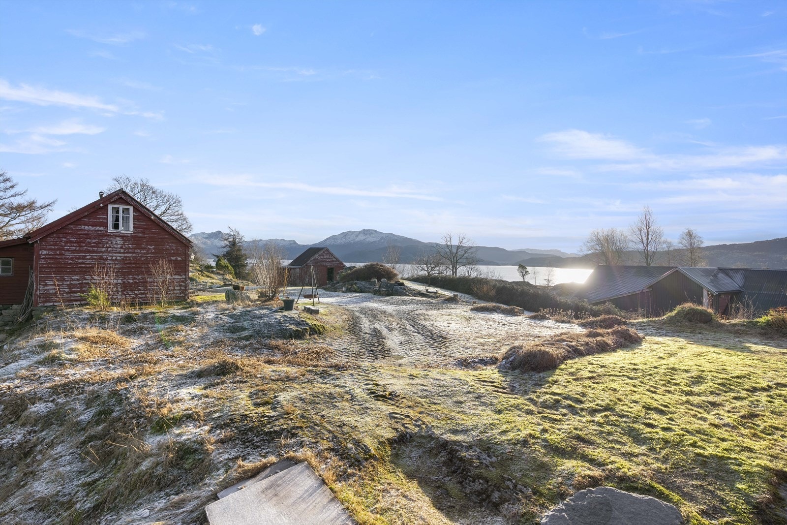 Frå tunet ser ein utover landskapet og dei mange bygningane som høyrer til garden. Galleribilde