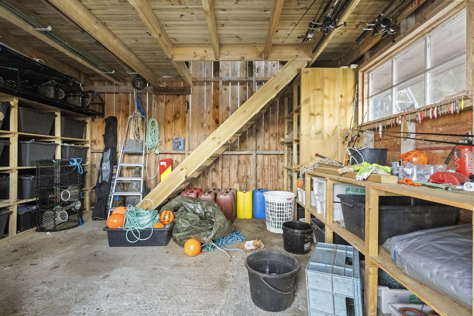 Første etasje i sjøbua er eit praktisk rom for oppbevaring av fiske- og båtutstyr. Galleribilde