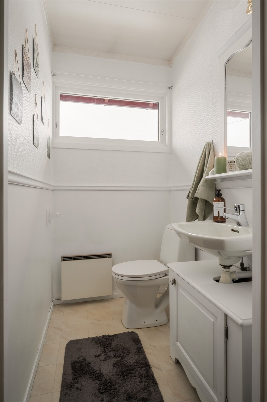 I tilknytning til disse soverommene er det et toalettrom med belegg på gulv og lysmalte overflater. Rommet er utstyrt med vegghengt servant med underskap, speil med belysning over, gulvstående toalett og panelovn. Galleribilde