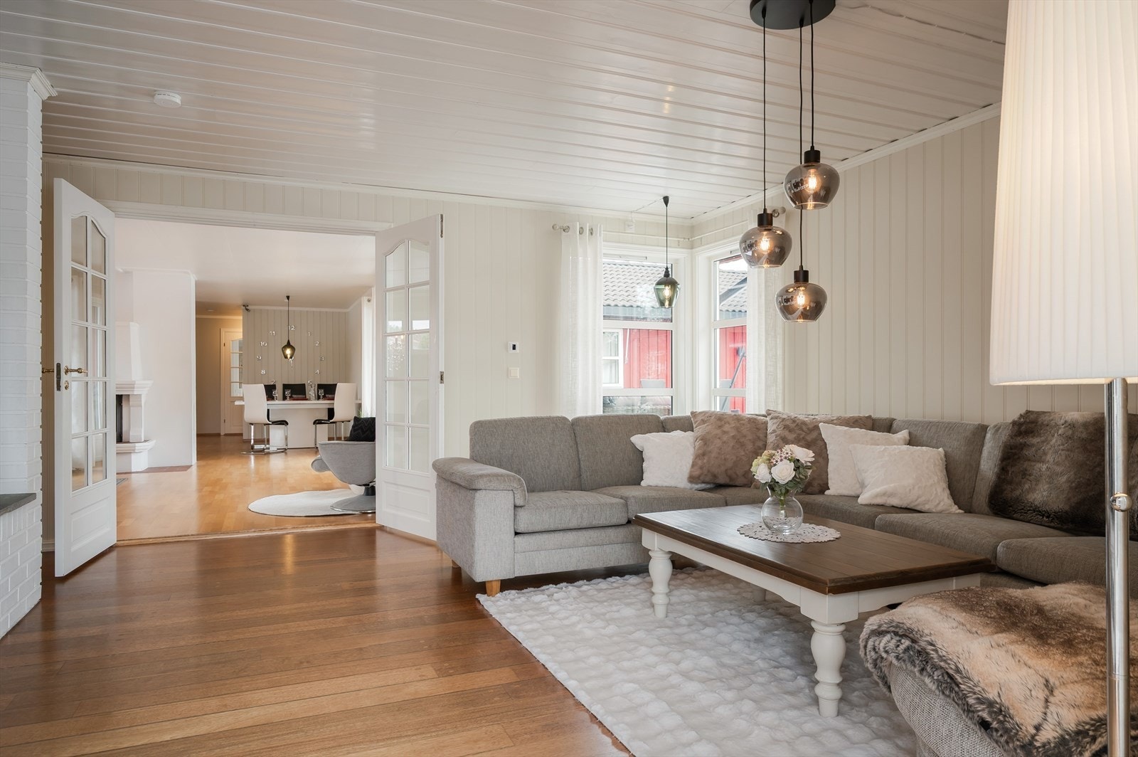 Tilbygget stue har pent gulv og lyse panelplater på veggene. Galleribilde