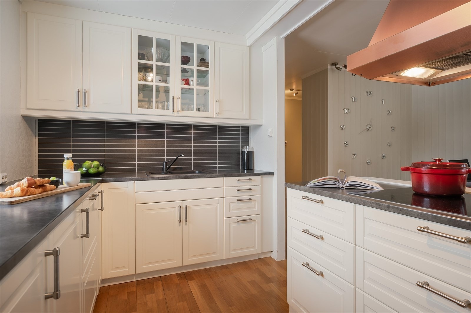 Innredningen har lyse profilerte fronter og laminert benkeplate med nedfelt oppvaskkum. Praktisk med flisimitasjonsplater i benkeryggen og belysning under overskapene. Galleribilde