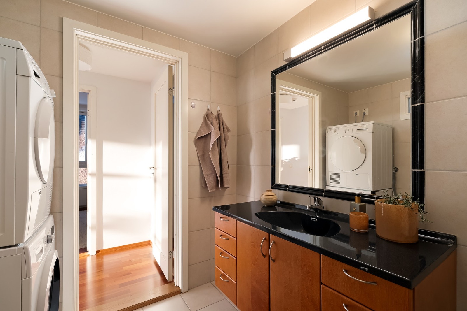 Badet har innredning med skap og skuffer samt ovenpåliggende servant. Over vasken er det et stort speil med belysning. Galleribilde
