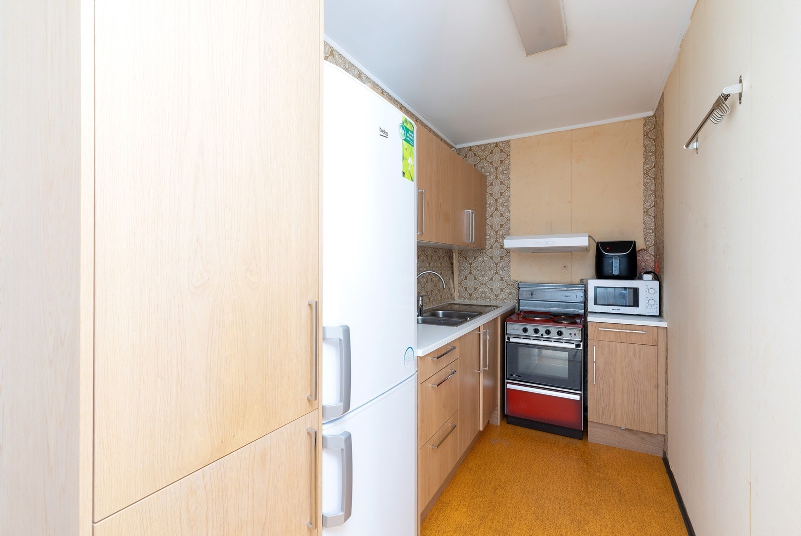 Kjøkken med skap og benkeplass. Komfyr og kjøleskap medfølger salget. Galleribilde