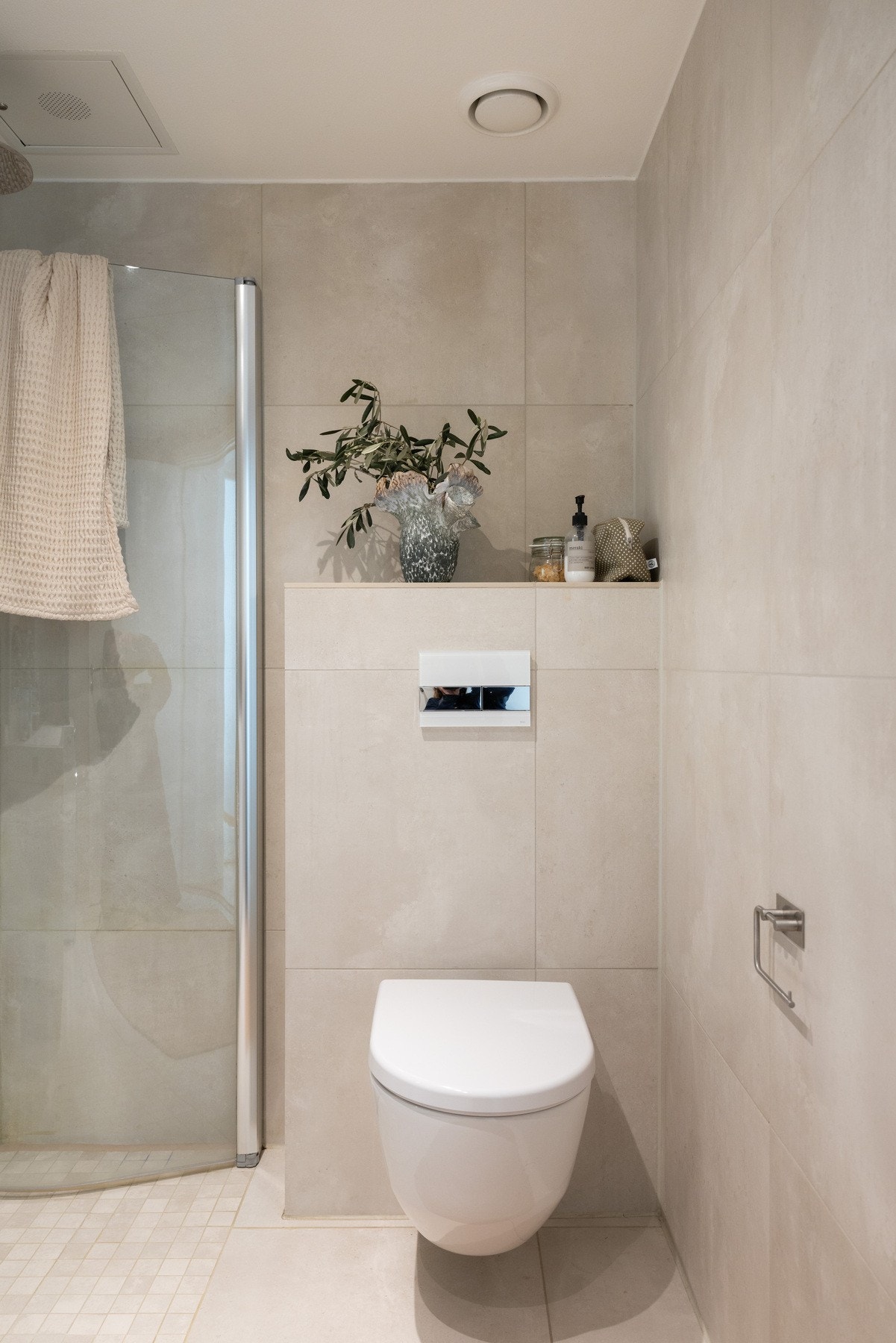 Badet er praktisk innredet med vegghengt toalett, servantmøbel med skuffer, speil med lys og dusjhjørne med glassdører. Opplegg for vaskemaskin. Galleribilde