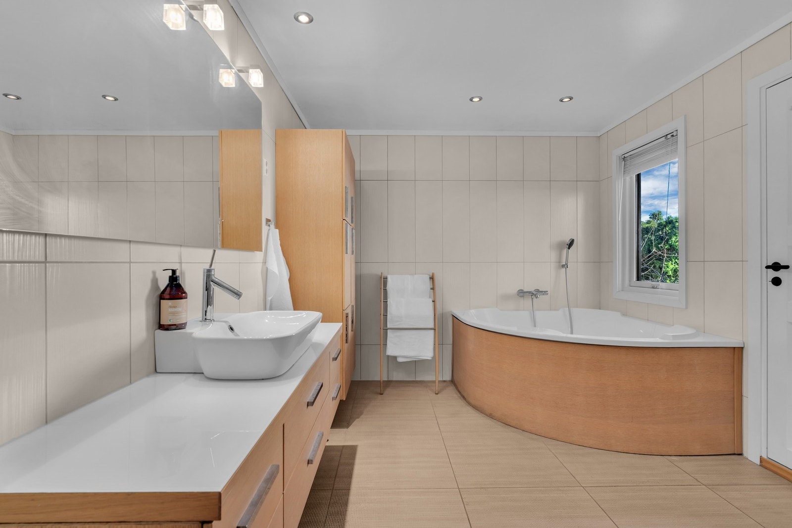Lekkert bad med badekar og moderne innredning Galleribilde