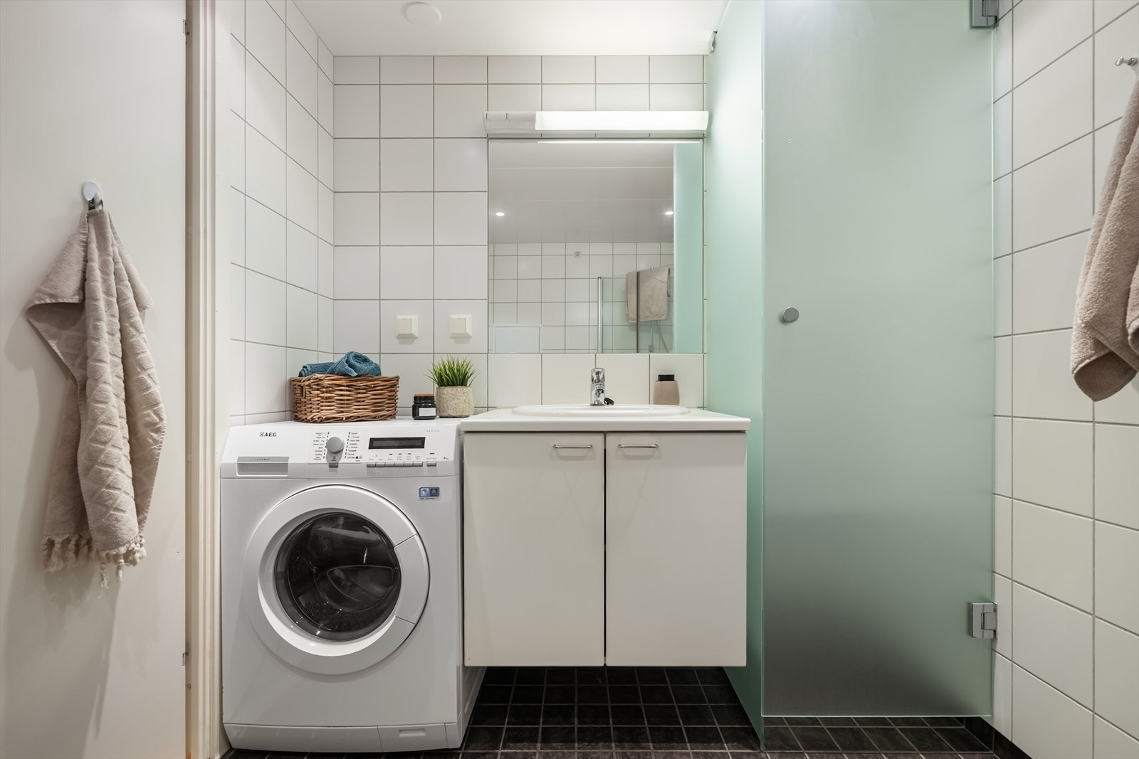 Innredningen består av servant med underskap, speil med belysning, veggmontert toalett og dusjløsning med glassdører. Det er også opplegg for vaskemaskin og tørketrommel. Galleribilde