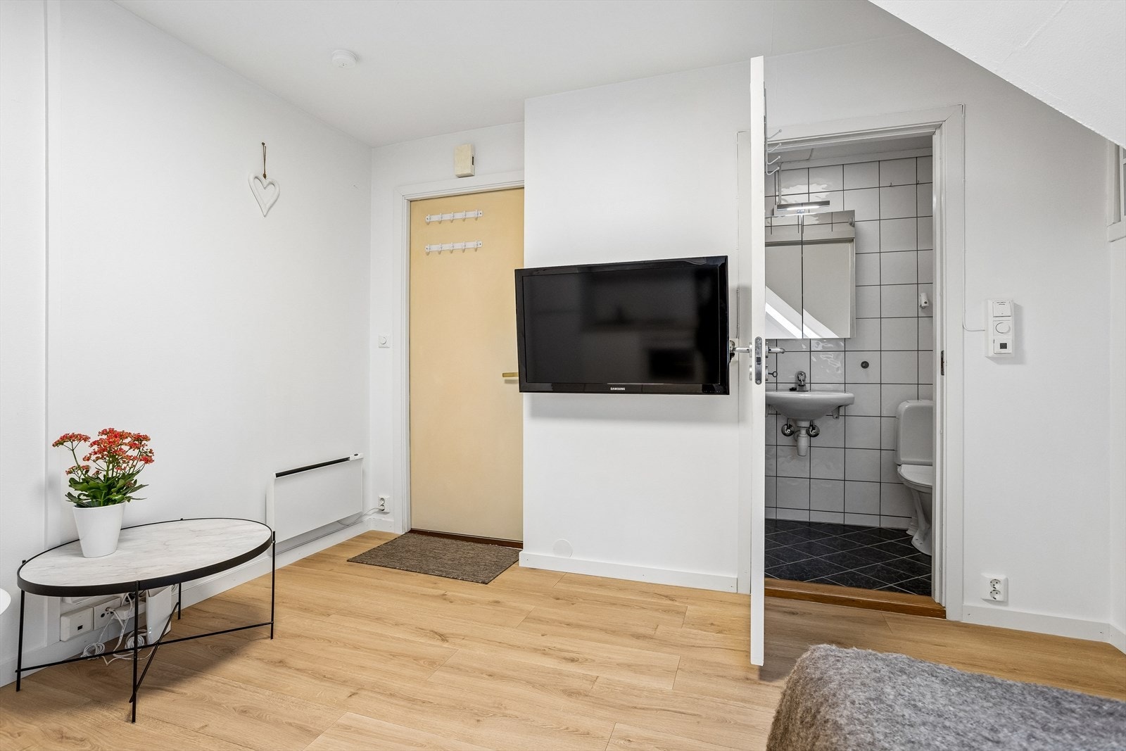Fra inngangspartiet ser du den praktiske planløsningen med direkte tilgang til badet. Hele leiligheten har gjennomgående laminatgulv. Galleribilde