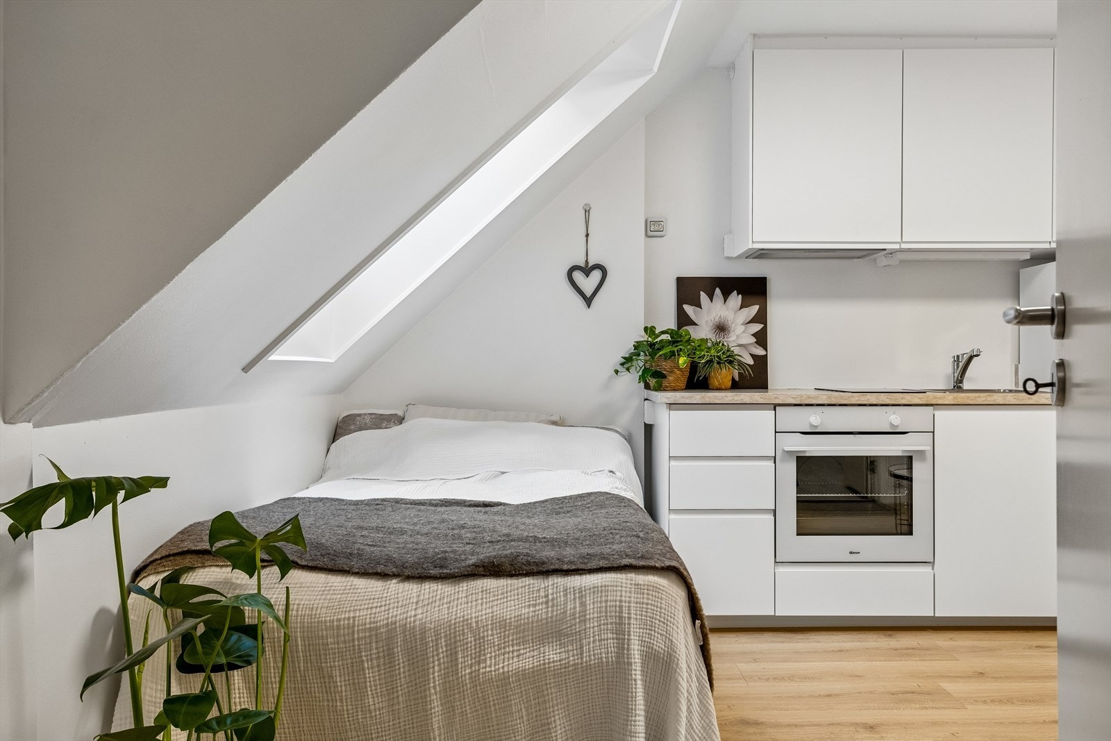 Sovealkoven er plassert lunt og smart under skråtaket, noe som skaper en adskilt og hyggelig sone i rommet. Galleribilde