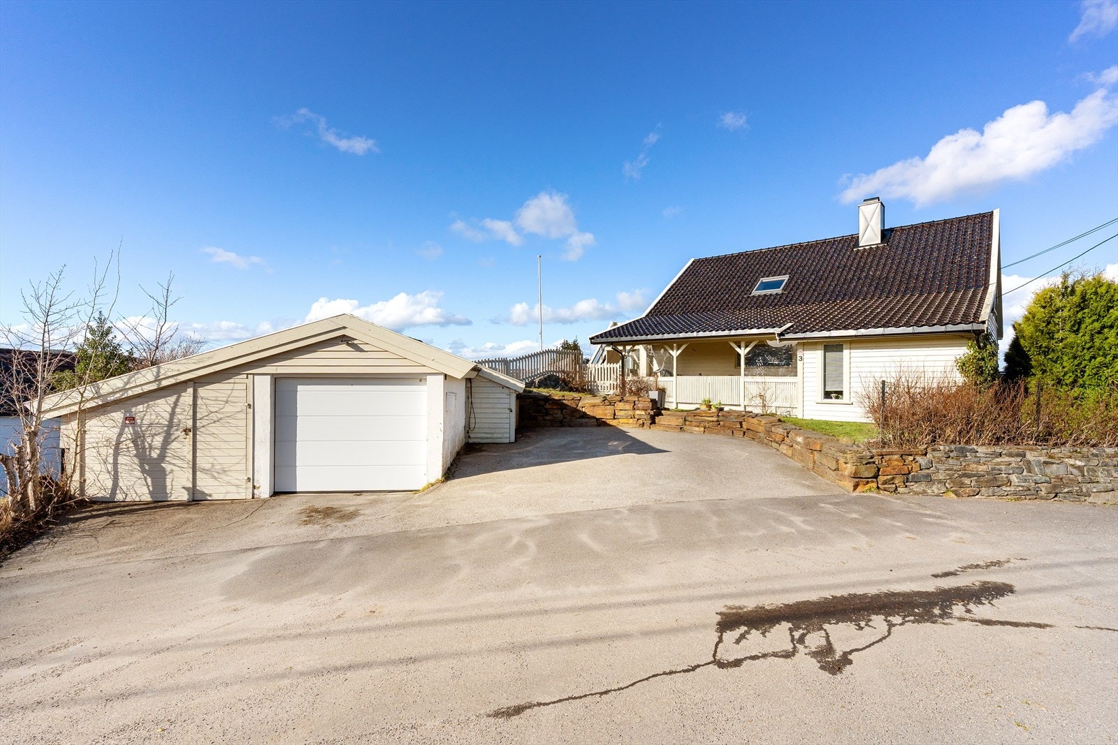 Asfaltert gårdsplass med garasje og bod | Det er elbil-lader i garasjen Galleribilde