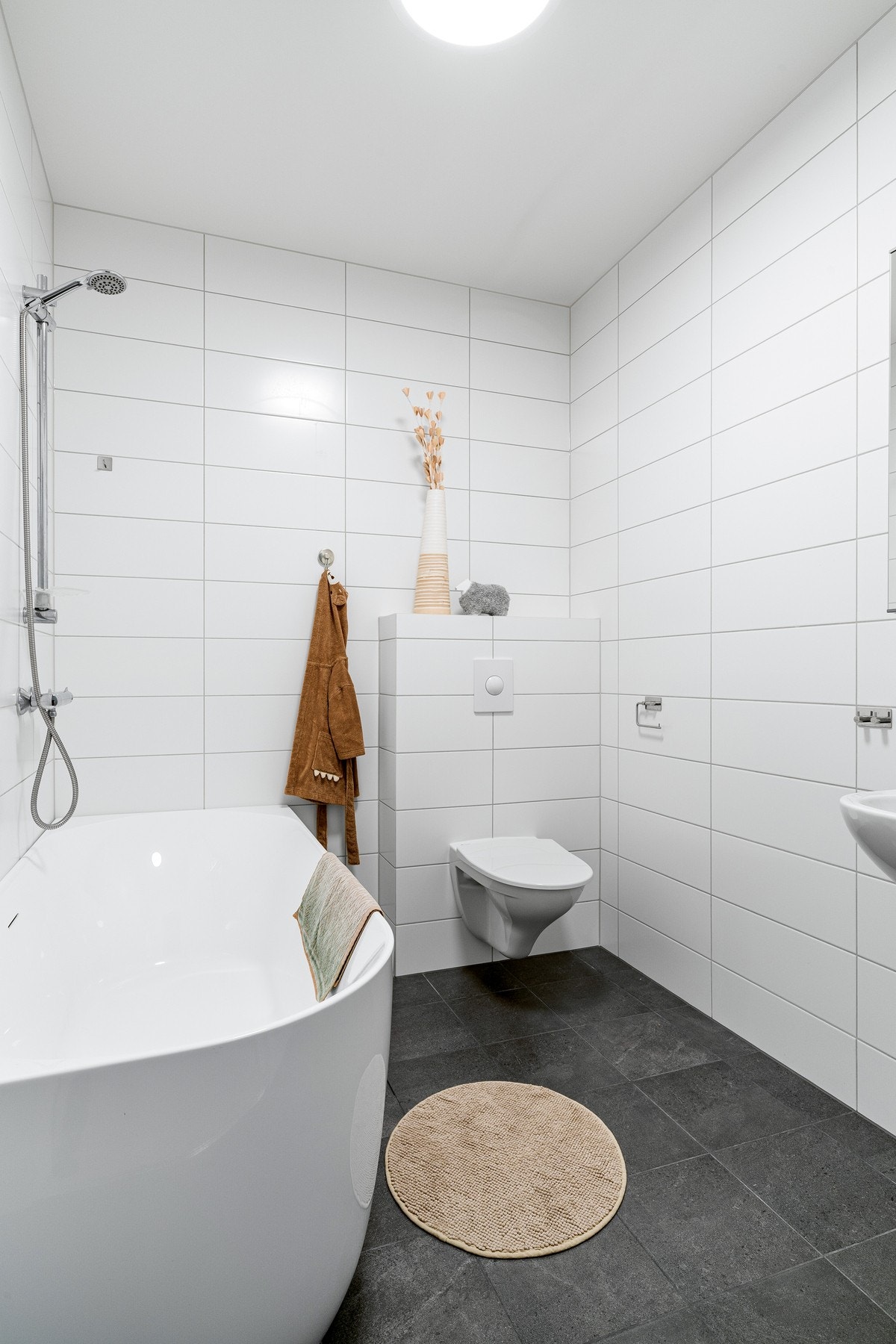 Rommet er utstyrt med servant, vegghengt toalett samt badekar med dusjløsning. Galleribilde