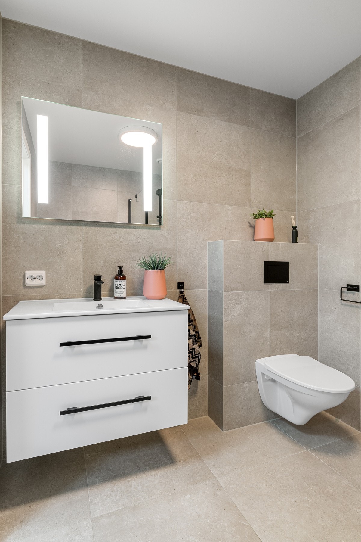 Innredningen består av en praktisk baderomsinnredning med nedfelt servant, vegghengt toalett og dusjhjørne. Galleribilde