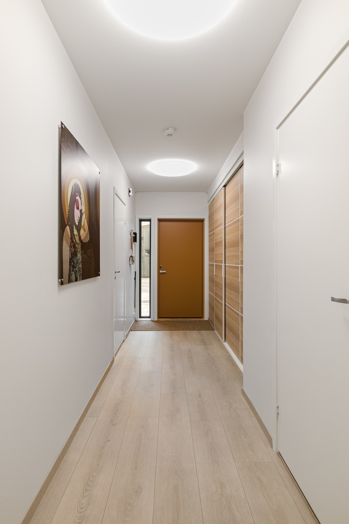 Entréen gir et godt førsteinntrykk med lyse overflater og en romslig utforming. Her er det godt med plass til å henge fra seg yttertøy og sette fra seg sko i en romslig skyvedørsgarderobe. Galleribilde