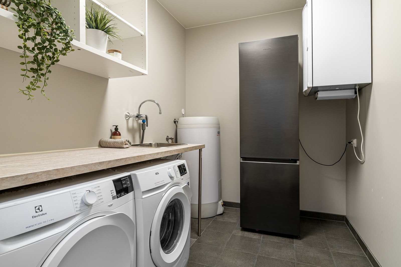 Boligens vaskerom har flislagt gulv og malte veggflater. Rommet er utstyrt med benkeplate med vask, samt opplegg for vaskemaskin og plass til tørketrommel. Galleribilde