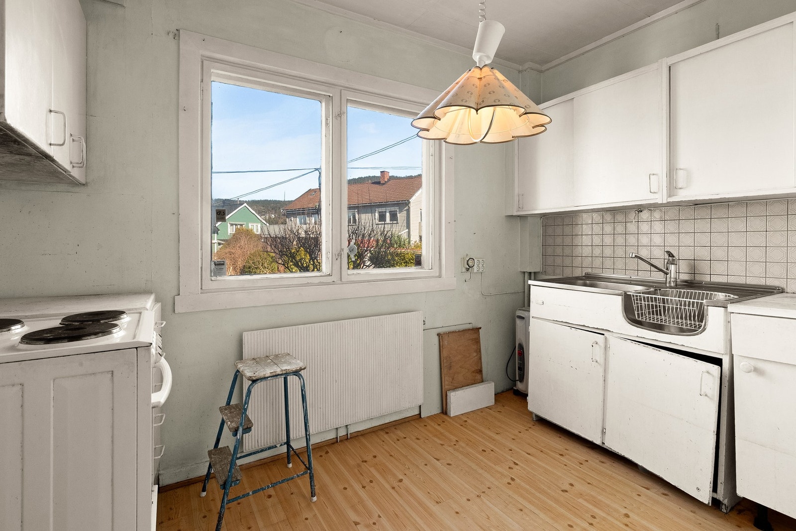 Kjøkken med eldre innredning med glatte fronter og frittstående komfyr. Galleribilde