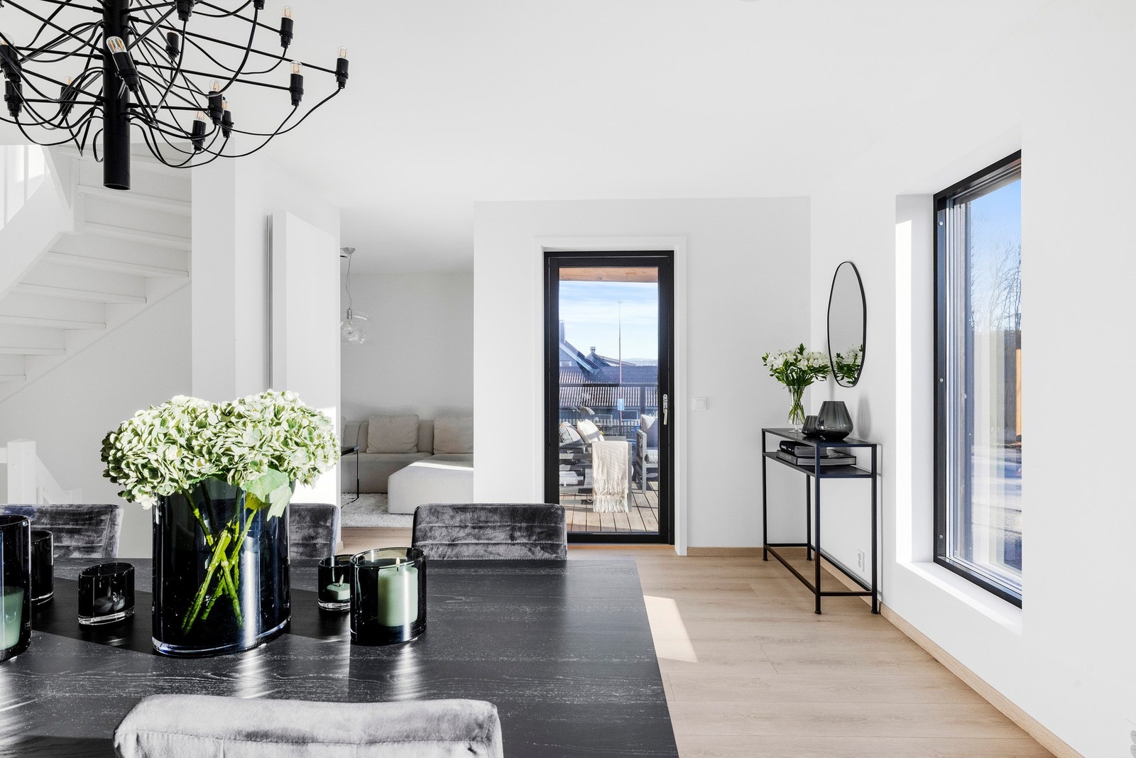 Utgang til solrik, overbygget balkong med glassrekkeverk som gir stuen en ekstra dimensjon. Galleribilde
