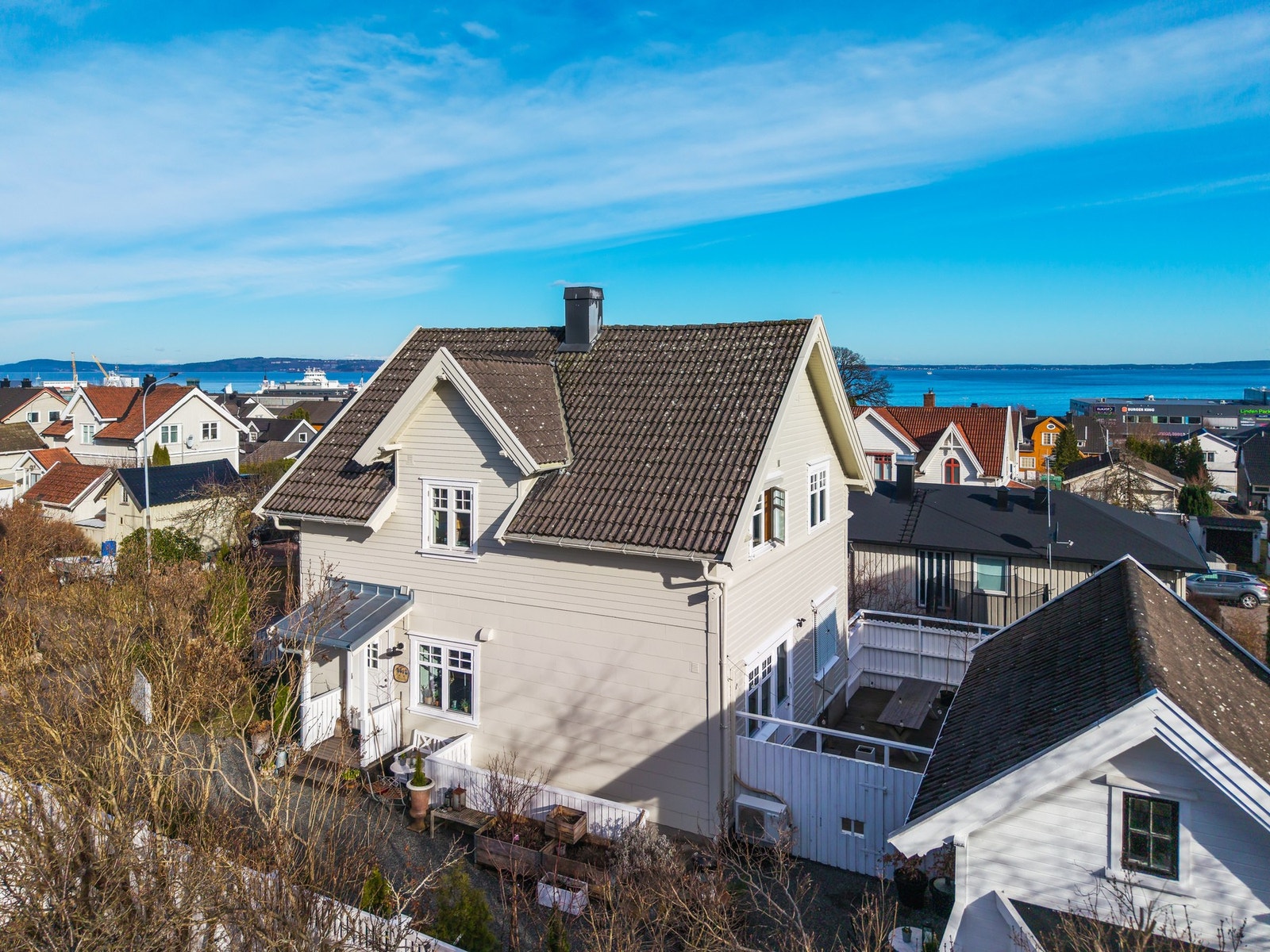 Her ser vi et vårbilde fra 2026 av inngangspartiet og terrassen - sommerstua til høyre Galleribilde