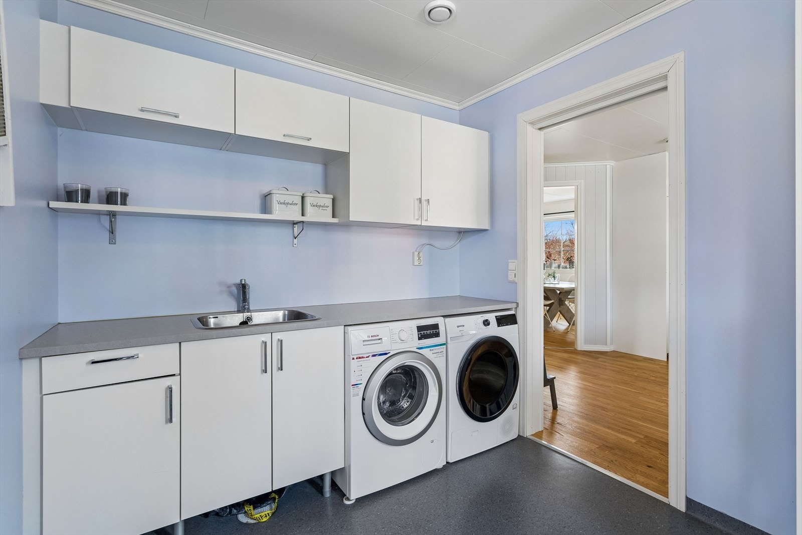 Praktisk vaskerom med egen bi-inngang. Rommet har vinylgulv med gulvvarme og opplegg for vaskemaskin. Galleribilde