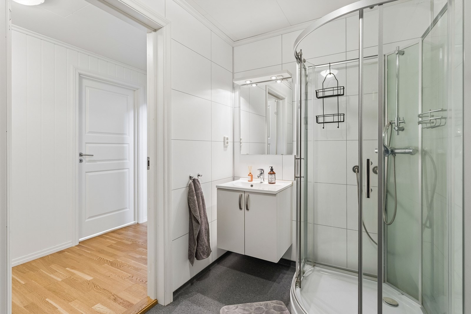 Badet i underetasjen er funksjonelt innredet med dusjkabinett, servant i innredning og gulvmontert WC. Galleribilde