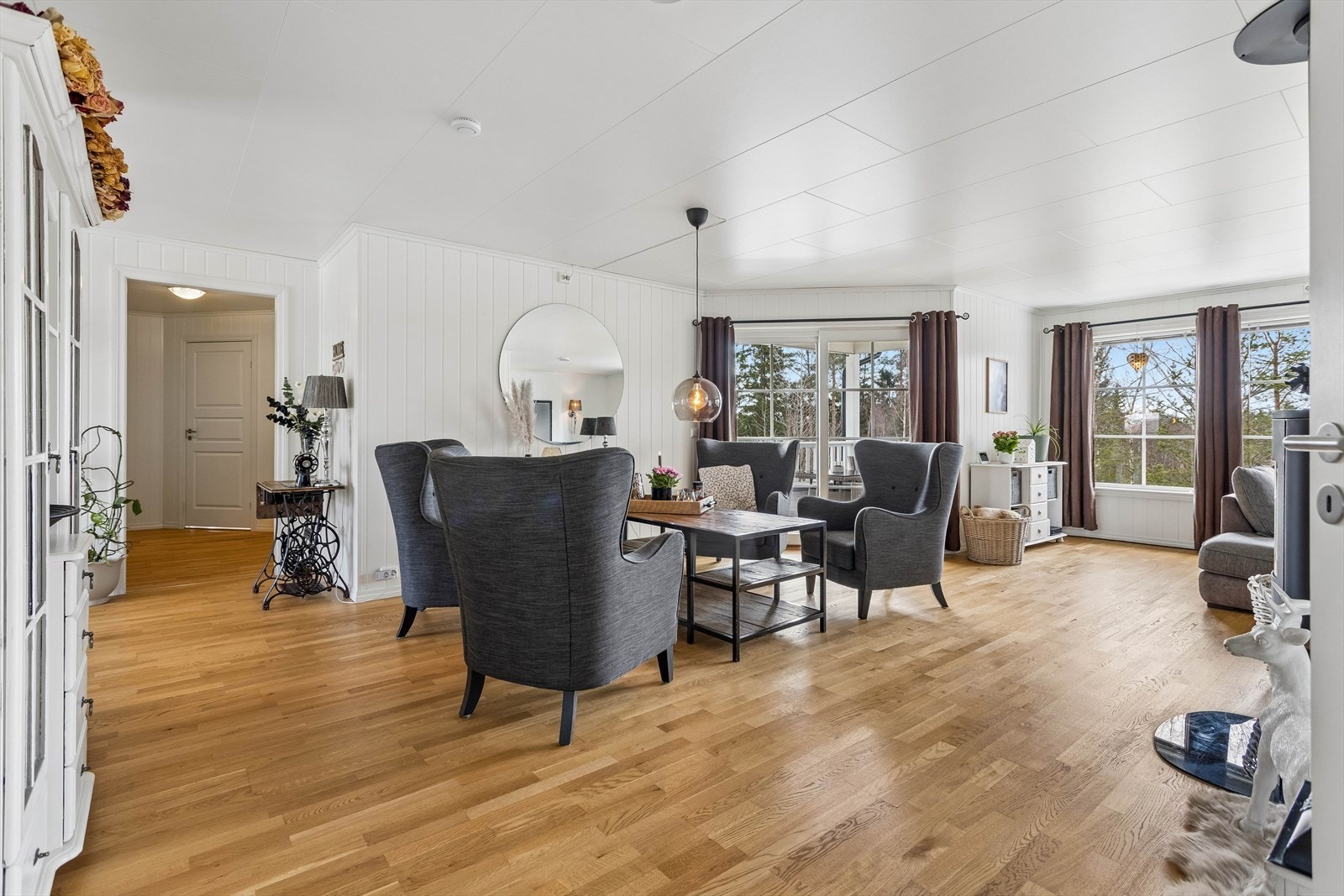 Vi går opp til første etasje. Den romslige stuen har gjennomgående parkettgulv og god plass til flere sittegrupper. Galleribilde