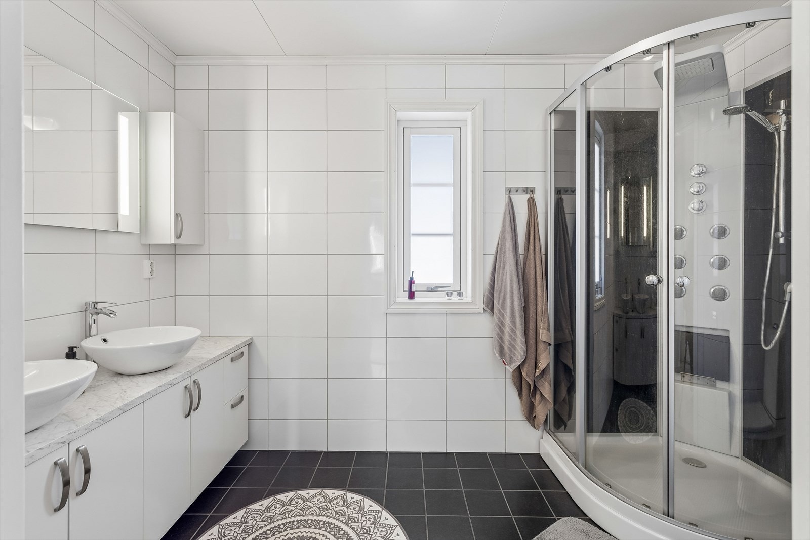 Hovedbadet er helfliset og utstyrt med elektrisk gulvvarme, dobbel servant og dusjkabinett. Galleribilde