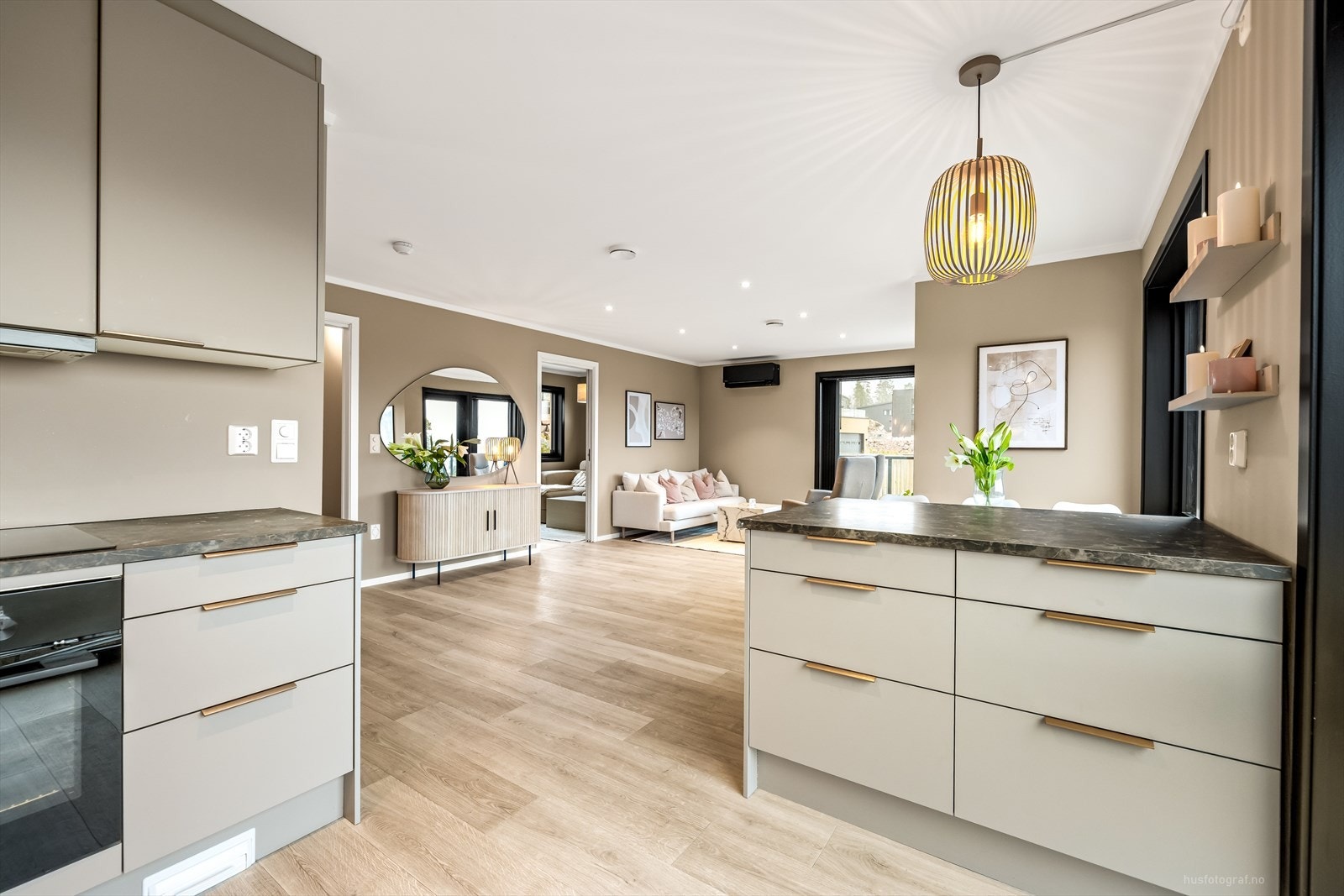 Enkel tilgang mellom stue og kjøkken, med downlights i taket og praktisk kjøkkenøy. Galleribilde