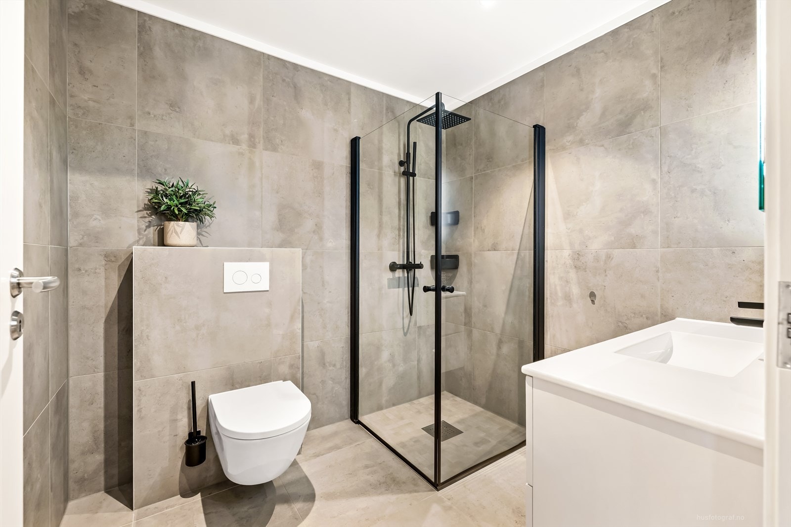 Bad 2 i 1.etasje har 60X60 fliser med varmekavler i gulv, hvis baderomsinnredning, dusjhjørne med regndusjarmatur og vegghengt toalett. Galleribilde